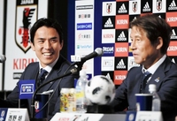 報道陣からの質問に笑顔を見せるサッカー日本代表の長谷部誠（左）。右は西野朗監督＝千葉・ヒルトン成田（撮影・開出牧）