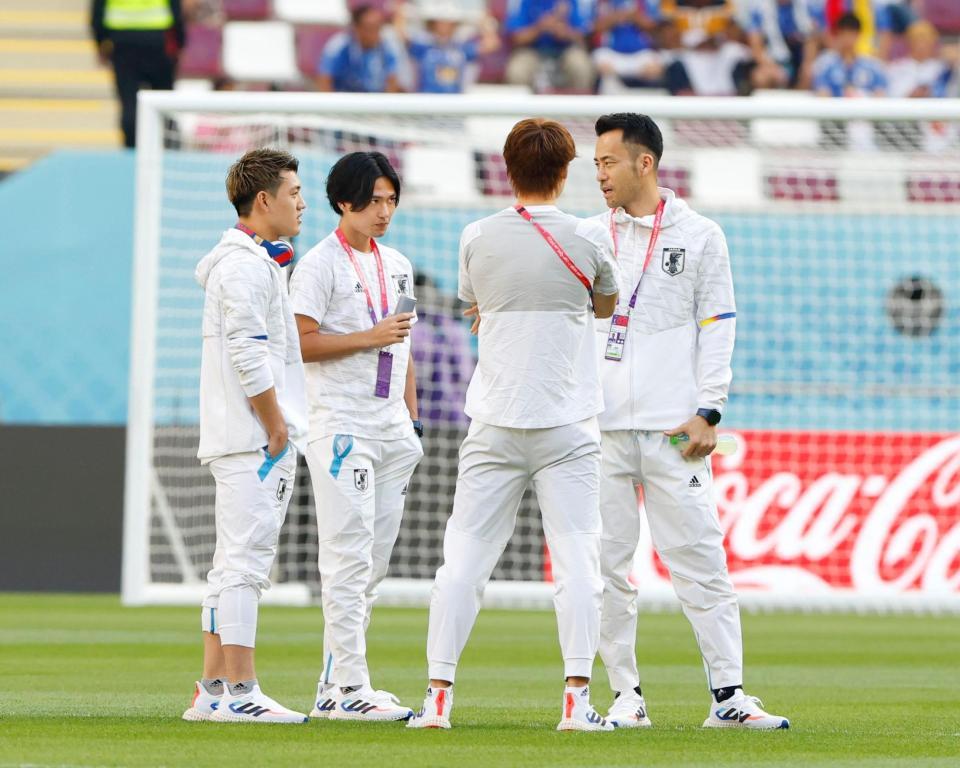 　ドイツ戦を前にピッチで話をする（左から）堂安、南野、（１人おいて）吉田（共同）