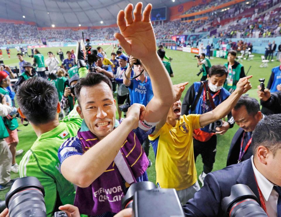 　スペインに逆転勝ちで決勝トーナメント進出を決め、笑顔でサポーターにあいさつする吉田（手前）＝共同