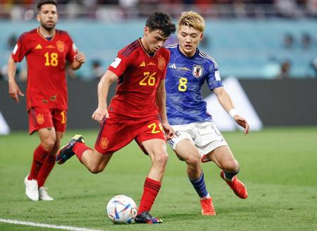 　スペインの後半、ペドリ（中央）と競り合う堂安＝１日、ドーハ（共同）