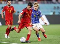 　スペインの後半、ペドリ（中央）と競り合う堂安＝１日、ドーハ（共同）