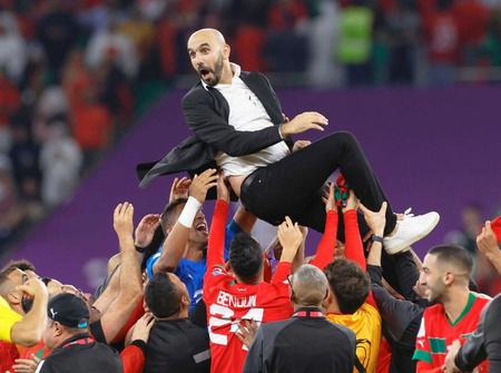 　ポルトガルに勝利し、選手たちに胴上げされるモロッコのレグラギ監督＝共同