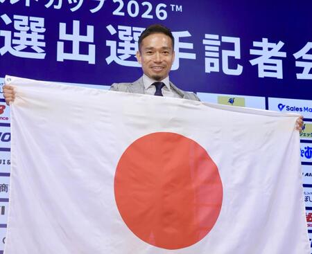 Ｗ杯代表選出選手記者会見で日の丸を手にポーズを決める長友＝５月１７日