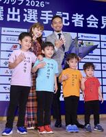 長友（後列右）の代表選出会見にサプライズ登場し、写真撮影に臨む妻の平愛梨（同左）＝５月１７日