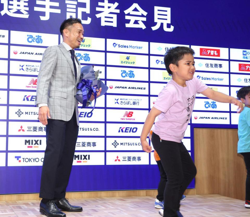 両手をつきあげ、報道陣を熱く鼓舞する長男。パパ長友も思わず笑顔＝５月１７日