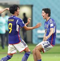 　２２年のＷ杯カタール大会で、決勝トーナメント進出を決め、喜ぶ三笘（左）と田中（右）＝共同