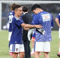 試合後、長友佑都（左）にキャプテンマークをつけてもらう遠藤航（撮影・中田匡峻）