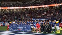 サポーターを背に集合写真を撮る日本代表イレブン（撮影・中田匡峻）