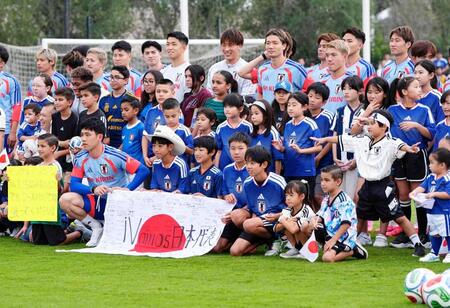 事前合宿で現地の子どもたちと写真に納まる日本代表＝モンテレイ近郊（共同）