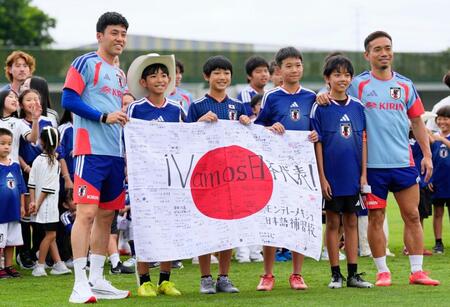 事前合宿で現地の子どもたちと写真に納まる遠藤（手前左端）と長友（同右端）＝モンテレイ近郊（共同）