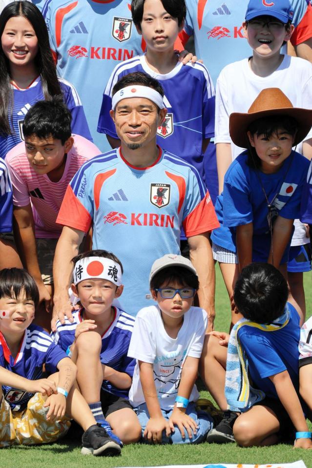 “おそろい”の日の丸バンド姿の子どもと笑顔で撮影する長友佑都（中央）