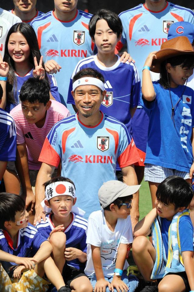 “おそろい”の日の丸バンド姿の子どもと笑顔で撮影する長友佑都（中央）