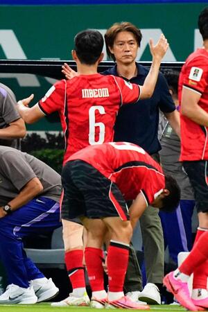 後半、同点ゴールを決めた黄仁範（６）を祝福する韓国の洪明甫監督（共同）