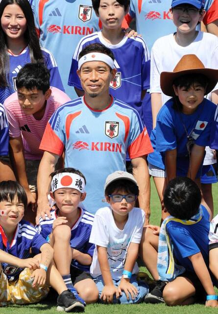 “おそろい”の日の丸バンド姿の子どもと笑顔で記念撮影する長友