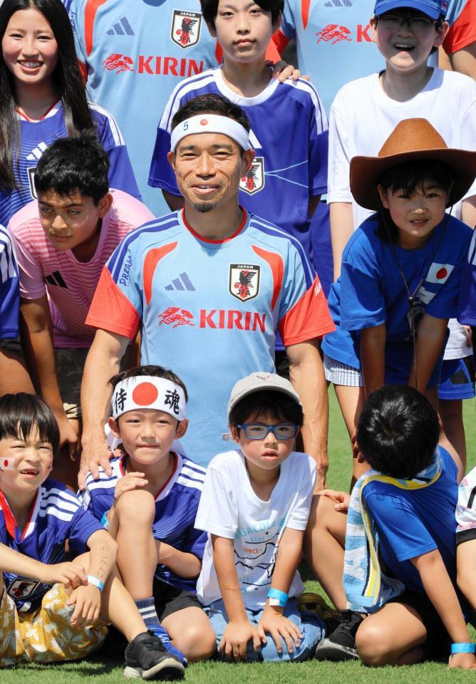 “おそろい”の日の丸バンド姿の子どもと笑顔で記念撮影する長友