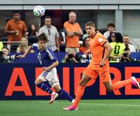 前半、オランダ選手と競り合う久保（左）