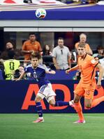 前半、オランダ選手と競り合う久保（左）
