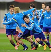 長友佑都（右手前）からタックルを受けてよろめく本田圭佑を見て、笑う柿谷曜一朗＝２０１４年