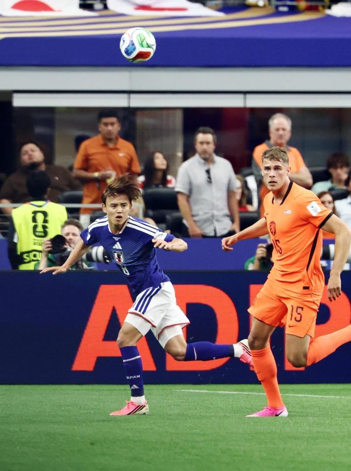 前半、オランダ選手と競り合う久保（左）