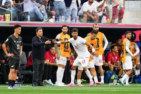 前半、ゴールを決め、ガレノイ監督とタッチを交わすイランのレザイアン（23）＝ロサンゼルス（共同）