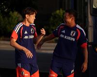 日本代表・長友佑都（右）と談笑しながら引き揚げる日本代表・鈴木唯人（撮影・中田匡峻）