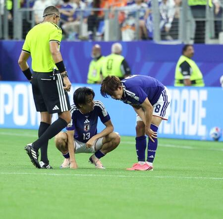 脚を痛めた久保建英を心配そうにのぞきこむ中村敬斗＝１４日、ダラス