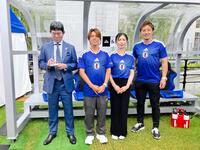 森保一監督の蝋人形と記念撮影する（右から）那須大亮さん、鮫島彩さん、森保圭悟さん