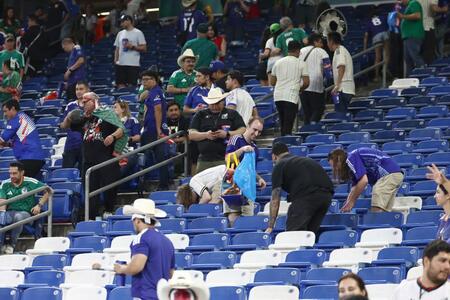 試合後、スタンドのごみを拾う観客ら
