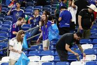試合後、ごみを拾う観客