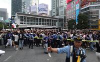 交通整理をする警察官と日本代表の勝利に盛り上がるサポーター（撮影・佐々木彰尚）