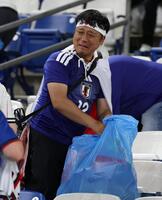 試合後、ゴミを拾うサポーター（撮影・中田匡峻）