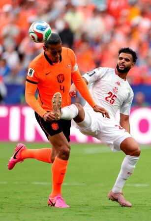競り合うオランダのファンダイク（左）とチュニジアのスリマン（ゲッティ＝共同）