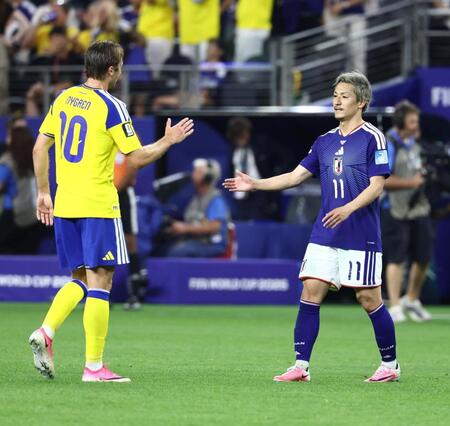 試合後、スウェーデンのニュグレン（左）と握手する前田