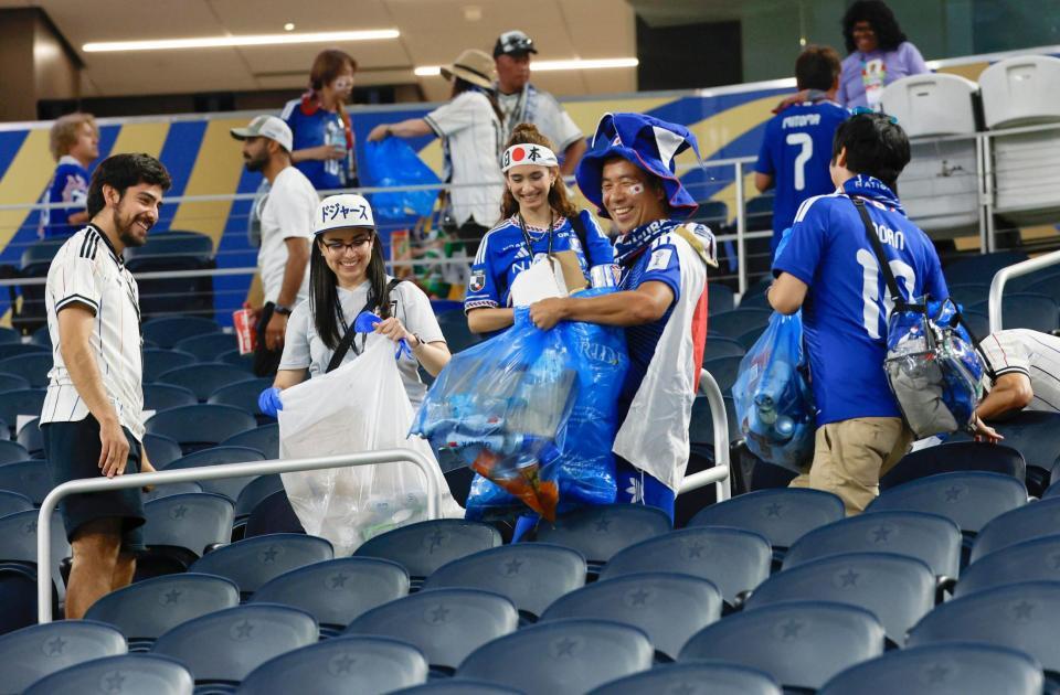 スウェーデン戦を終え、ごみ拾いをする日本サポーター（共同）
