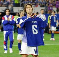 遠藤のユニホームを手に声援に応える板倉（共同）