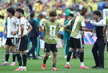 ブラジルに敗れ、腰に手を当てる久保（中）ら日本イレブン。右端は森保監督