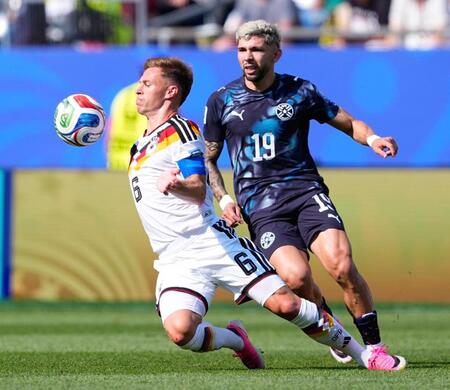 前半、競り合うドイツのキミヒ（左）とパラグアイのエンシソ＝ボストン（ＡＰ＝共同）