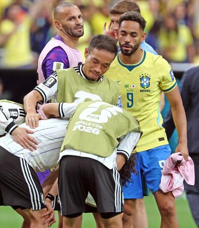 試合後、号泣する田中（手前左）をなぐさめる長友（中央）とブラジルのクニャ（右）