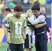 ブラジルに敗れ、肩を落とす久保。右は森保監督