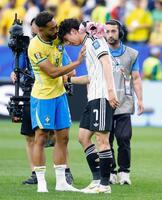 試合を終え、肩を落とす田中をねぎらうブラジルのクニャ（左）＝共同