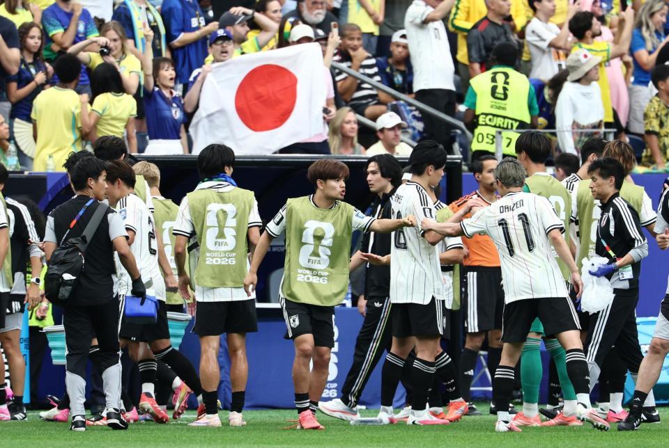 後半、飲水タイムで日本イレブンに声をかける久保（中）