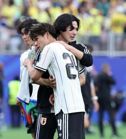 佐野海舟（手前）と抱擁を交わす南野拓実＝ヒューストンスタジアム（撮影・中田匡峻）