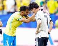　肩を落とす田中をねぎらうブラジルのクニャ（左）＝共同