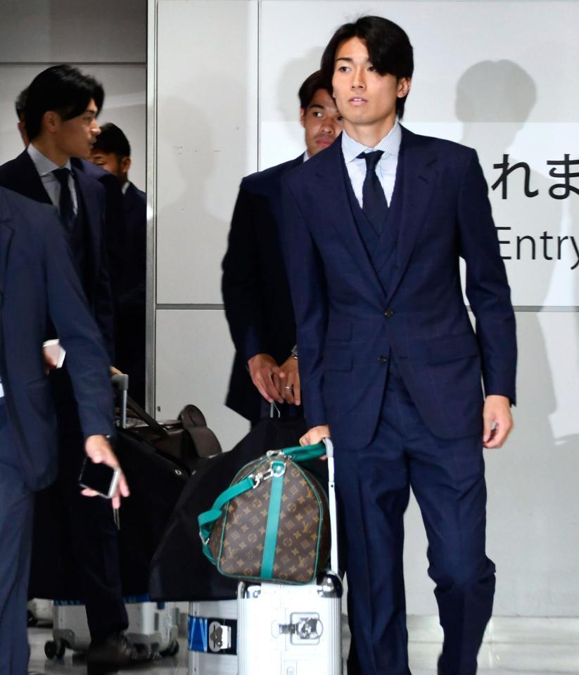 サッカーＷ杯北中米３カ国大会を終え帰国した中村（手前）ら＝２日午後、成田空港