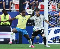 前半、ビニシウス（左）と競り合う冨安＝６月２９日