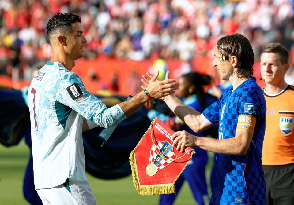 試合前、タッチを交わすポルトガルのロナウド（左）とクロアチアのモドリッチ（共同）