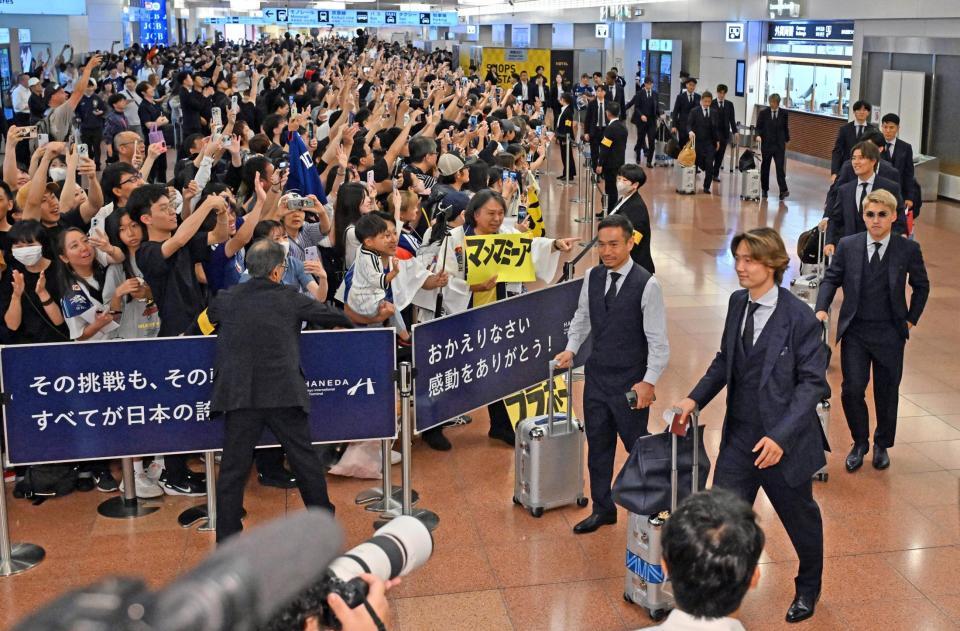 サッカーＷ杯北中米３カ国大会を終え帰国し、多くのサポーターらに迎えられる日本代表の（手前左から）長友、板倉、堂安ら＝羽田空港（２日）