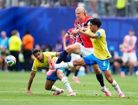 前半、競り合うノルウェーのハーランド（中央）＝共同