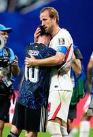 試合後、アルゼンチンのメッシ（左）と健闘をたたえ合うイングランドのケーン（共同）
