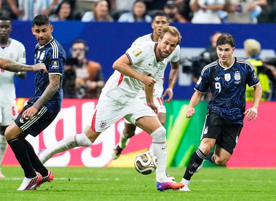 後半、競り合うイングランドのケーン（中央）＝共同